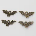 Close-up of four vintage bronze bat charms for DIY jewelry with detailed wing textures - Antique Bronze