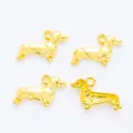 Makro-Detail von vier goldenen Dackel-Anhängern für DIY-Schmuckherstellung und Basteln - Gold