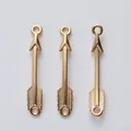Macro shot of three golden arrow connector charms for vintage jewelry making and DIY crafts - KC Gold