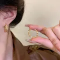 Minimalistische goldene gedrehte Creolen mit poliertem Finish am Modell und Nahaufnahme - Spiralverdrehte polierte Creolen (A1285) / Gold
