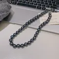 Collar de perlas gris oscuro con cierre plateado sobre un ordenador portátil - Collar de Perlas de Imitación (X1332) / 12mm / Gris