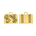 Detailed view of vintage gold suitcase charms with city initials and linear patterns - Antique Gold