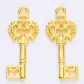 Close-up of golden vintage baroque hollow key pendants with intricate floral details - Gold