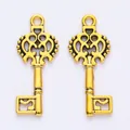 Detailed macro of golden alloy vintage key pendants with ornate hollowed patterns - Antique Gold