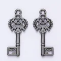Detailed macro view of vintage alloy key charms with intricate crown hollow patterns - Gun Black
