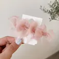 Lot de barrettes en organza rose sur carte présentées sur un fond doux et clair - Rose