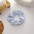 Light blue waffle knit scrunchie with soft textured fabric and elegant ruffle design - Blue