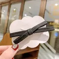Elegant black fabric ribbon bow hair clip displayed on a white cloud-shaped card - Black