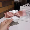 Pink satin bow hair clip with glossy silk finish on fashion jewelry display card - Pink
