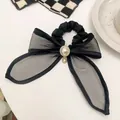Dettaglio dell'elastico a fiocco in organza nera con perla centrale e cristalli lucenti - Elastico per capelli nero