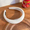Thickened white padded headband with quilted texture and handmade label on wood - White