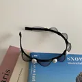 Elegant black mesh headband with white pearls on light background with books - Black