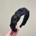 Detailed texture of black organza twist headband with sparkling rhinestone heart accents - Black