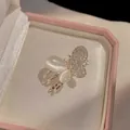 Detailed macro view of silver butterfly clip with white cat-eye stones and sparkling crystals - Butterfly Style