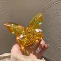 Detalle de pinza para el pelo de mariposa ámbar con resina tallada y muelle metálico - Degradado Multicolor