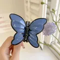 Navy blue butterfly hair claw clip with glossy finish and secure metal spring - Blue