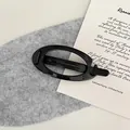 Klassische schwarze Haarklammer aus Acryl in ovaler Form mit glänzendem Finish und Metallfeder - Schwarz