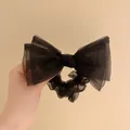 Vue détaillée d'un grand chouchou nœud en organza noir avec texture maille légère - Noir