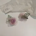 Dettaglio del fermaglio a camelia in tulle rosa sfumato con foglie ricamate verdi - Fermaglio per capelli