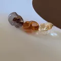 Detail of irregular resin crystals in amber and grey on a gold hair clip base - Brown Mix Color