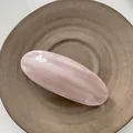 Detalle macro de pinza de pelo ovalada con mármol rosa y blanco y letras doradas - Rosa