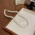 Élégant collier de perles blanches 8mm avec fermoir doré sur plateau à bijoux en bois - 8mm Perle (X1399)