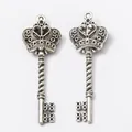 Vintage silver crown key pendant in retro alloy with embossed relief design on white background - Antique Silver