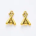 Macro shot of two vintage golden baseball and crossed bats charms with stitched texture - Antique Gold