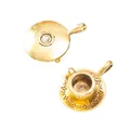 Macro view of vintage golden tea cup and saucer metal charms with floral relief detail - Antique Gold