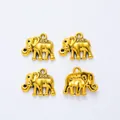 Detailed macro view of four vintage golden elephant alloy charms for DIY jewelry making - Antique Gold