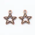 Macro detail of two vintage bronze star pendants with hollow centers and beaded edges - Antique Red Copper