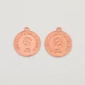 Detailed macro view of a rose gold coin pendant featuring a Queen Elizabeth relief - Rose Gold