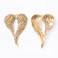 Detailed view of vintage gold angel wing pendants showing front texture and back structure - Antique Gold