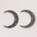 Vista macro di due ciondoli a luna scavata in lega d'argento vintage per DIY - Canna di Fucile