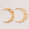Dettaglio di due ciondoli a forma di luna con intricati motivi in filigrana dorata - Oro KC