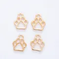 Macro detail of four gold bear paw pendants with hollow design and smooth metal finish - KC Gold