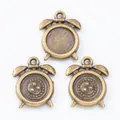Macro shot of three bronze alarm clock charms showing bezel base and textured back for DIY jewelry - Antique Bronze