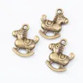 Three vintage bronze rocking horse pendants for DIY jewelry making on white background - Antique Bronze