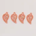 Detail of four rose gold alloy leaf pendants with intricate hollow patterns for DIY jewelry - Rose Gold