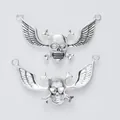 Vue détaillée du pendentif tête de mort avec ailes en alliage argenté antique et deux anneaux - Argent antique