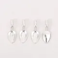 Close-up of four silver teardrop alloy pendant bases with textured diamond patterns - Bright Silver