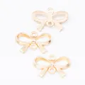 Close-up of three gold bow-shaped alloy connectors for DIY jewelry making with dual loops - KC Gold