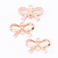 Macro view of rose gold zinc alloy bow pendants with double hanging loops for DIY jewelry - Rose Gold