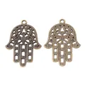 Vintage bronze Hamsa Hand alloy charm showing detailed hollow floral patterns and textured back - Antique Bronze