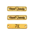 Makroaufnahme rechteckiger antiker Goldlegierungsetiketten mit Hand Made Gravur - Handmade Buchstabenschild Stil / Altgold