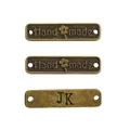 Drei rechteckige Vintage-Metallanhänger in Bronze mit Handmade-Schriftzug und Blumenmuster - Handmade Buchstabenschild Stil / Antikbronze