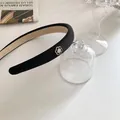 Détail du serre-tête noir en tissu orné d'une fleur de camélia avec revêtement antidérapant - Noir