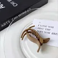 Matte coffee brown hair claw clip in a cross-tooth design on a glass plate - Dark Coffee