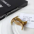 Elegant matte brown streamlined ponytail clip on a white plate with aesthetic props - Light Coffee (Streamlined)