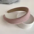 Detail of light pink velvet sponge headband with diagonal ribbed texture on a white plate - Ribbed Pink